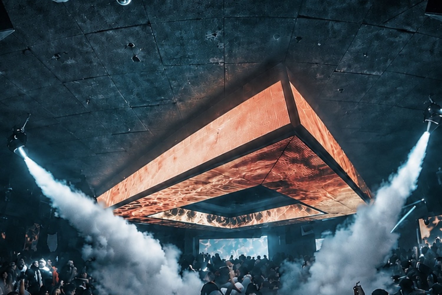 DJ performing under a suspended LED ceiling with smoke jets over a full dance floor